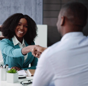 Two people smiling and shaking hands